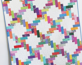 May include: A colorful quilt pattern called "Jelly Twist" is a jelly roll quilt in 4 sizes. The quilt is made with bright, colorful fabric scraps in a zig-zag pattern.