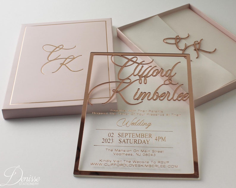 Puede incluir: Una invitaci&oacute;n de boda en oro rosa con los nombres "Clifford & Kimberlee" en escritura elegante. La invitaci&oacute;n incluye la fecha, hora y lugar. Tambi&eacute;n se ve una caja y unas iniciales a juego.