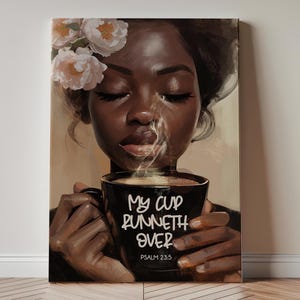May include: A canvas print depicts a Black woman with closed eyes, adorned with flowers, holding a steaming black coffee mug. The mug features the text "My cup runneth over" and Psalm 23:5.