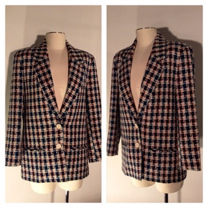 Könnte beinhalten: Ein schwarzer, weißer und rosafarbener karierter Blazer mit einem Knopfverschluss. Der Blazer hat einen Schalkragen und zwei Taschen.