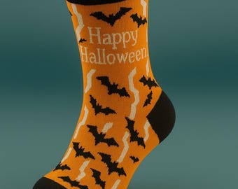 Puede incluir: Calcetín naranja con temática de Halloween con murciélagos negros y la frase "Happy Halloween" en blanco. El calcetín tiene un talón y una puntera negros, y una banda negra en la parte superior. También hay líneas onduladas blancas.