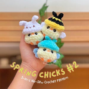 May include: Three small, round, crocheted chicks with orange beaks and black eyes. One wears a white bunny-ear hat, one a yellow and black striped bee hat, and one a bright blue hat. Text reads: SPRING CHICKS #2 3-in-1 No-Sew Crochet Pattern.