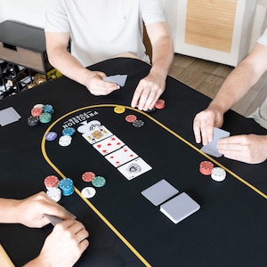 Może przedstawiać: Czarny stół do pokera z filcu z złotą obwódką i logo "PRECISION POKER". Stół jest przygotowany do gry w pokera z żetonami, kartami i kartami do gry.