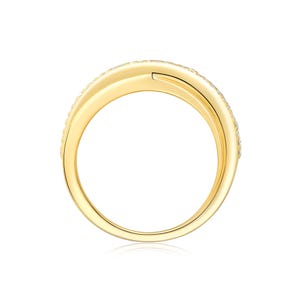 May include: A gold-colored ring with a double-band design. The top band is encrusted with small, clear gemstones. The ring is set against a white background, with a slight reflection visible below.