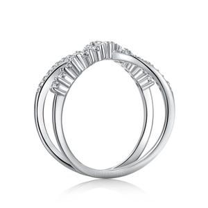 May include: A silver-colored ring with a unique, intertwined design. The ring features a curved top section adorned with small, sparkling stones, likely diamonds or cubic zirconia. The band has a double-loop design, creating an elegant and modern look. The ring is a piece of jewelry.