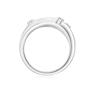Puede incluir: Un anillo plateado con un dise&ntilde;o &uacute;nico, adornado con peque&ntilde;as piedras preciosas transparentes. El anillo presenta una ca&ntilde;a dividida y una superficie texturizada, creando un aspecto moderno y elegante. Las piedras preciosas est&aacute;n engastadas para a&ntilde;adir brillo.