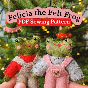 Puede incluir: Dos adornos de fieltro de rana, uno con un peto rojo y beige, el otro con un peto rosa. Las ranas tienen cuerpos verdes, mejillas rosas y labios rojos. El texto dice "Felicia the Felt Frog PDF Sewing Pattern".