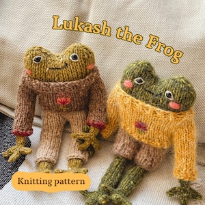 Puede incluir: Dos muñecos de rana tejidos, uno con un suéter y pantalón marrón, el otro con un suéter amarillo y pantalón marrón. Los muñecos tienen cuerpos verdes, caras sonrientes y el texto "Lukash the Frog" encima. Las palabras "Knitting pattern" están en la parte inferior.