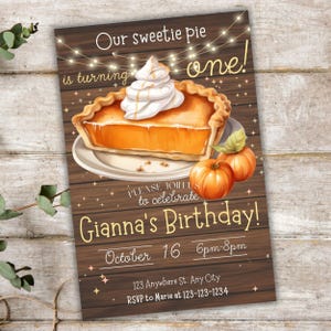 Peut inclure: Une invitation d'anniversaire avec une illustration de tarte à la citrouille et de la crème fouettée. Le texte dit "Our sweetie pie is turning one!" et "Gianna's Birthday!" sur un fond en bois.