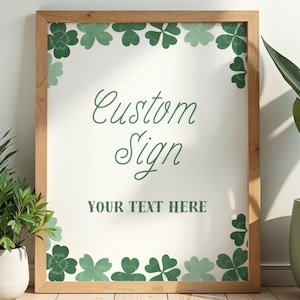 Puede incluir: Un letrero personalizado enmarcado con un borde de madera clara. El fondo blanco presenta detalles de tréboles verdes y las palabras "Custom Sign" y "YOUR TEXT HERE" en verde.