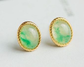 Könnte beinhalten: Ein Paar goldene Ohrringe mit grünen Jade-Steinen, die in einem seilartigen Design gefasst sind.