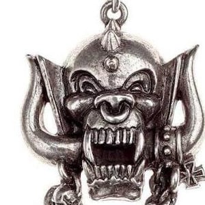 May include: Silver necklace with a detailed pendant of a snarling, demonic creature with horns and a chain. The pendant is attached to a silver chain.
