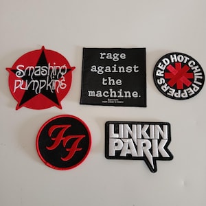 Może przedstawiać: Kolekcja haftowanych naszywek z logo zespołów muzycznych. Zawiera naszywki The Smashing Pumpkins, Rage Against the Machine, Red Hot Chili Peppers, Foo Fighters i Linkin Park. Każda naszywka ma unikalny design i kolorystykę.