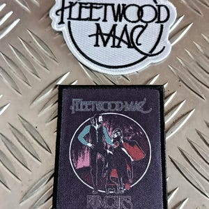 May include: Two embroidered patches featuring the band Fleetwood Mac. One patch is circular with the band's name in black script on a white background. The other is rectangular, with a band illustration and the band's name.