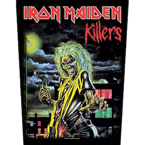 Peut inclure: Graphique noir avec le logo du groupe Iron Maiden et le mot "Killers" en rouge. L'image représente une figure squelettique aux cheveux verts, tenant une arme, sur fond de paysage urbain nocturne avec une pleine lune.