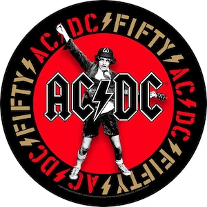 May include: Round sticker featuring the band AC/DC. The design includes a red circle with the band's name in bold white letters and a stylized lightning bolt. The band member is wearing a school uniform and holding a guitar.
