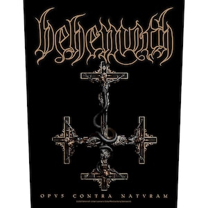 May include: Black graphic featuring the band name "Behemoth" in gold script above a detailed inverted cross design. The cross has a crucified figure and a serpent entwined around it. The text "OPVS CONTRA NATVRAM" is at the bottom.