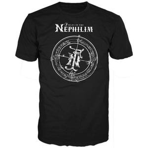 May include: Black t-shirt with a white graphic. The graphic features the text "Fields of the Nephilim" above a circular design with an ornate symbol in the center. The design is detailed and intricate.