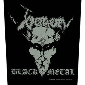 Può includere: Toppa in bianco e nero con il nome della band "Venom" in un font stilizzato. La toppa presenta un viso demoniaco con corna e un pentagramma sulla fronte. Il testo "Black Metal" è sotto l'immagine.