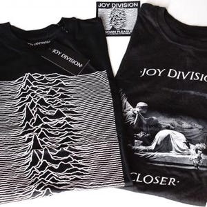 Könnte beinhalten: Zwei schwarze T-Shirts mit Joy Division-Grafiken. Ein Shirt zeigt das weiße Pulsar-Wellenmuster von Unknown Pleasures, das andere das Cover-Artwork des Albums Closer. Beide T-Shirts sind mit Joy Division-Markenetiketten versehen.