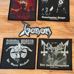 Puede incluir: Un conjunto de parches bordados en blanco y negro con logotipos y obras de arte de bandas de heavy metal. Los parches incluyen logotipos de Deicide, Venom, Dimmu Borgir y Mayhem, con textos como "Transiluantan Hunger" y "Pure Fucking Armageddon".