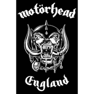 Op de afbeelding: Zwart-wit afbeelding met het Motörhead-logo. Het ontwerp bevat een schedel met slagtanden, een helm met spikes en kettingen. Het woord "England" staat eronder.