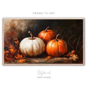 May include: A painting of three pumpkins, one white and two orange, with fall leaves scattered around them. The pumpkins are arranged in a still life composition on a dark background.