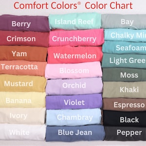 Puede incluir: Una carta de colores muestra una variedad de camisetas Comfort Colors&reg; en varios tonos. La carta incluye colores como Berry, Crimson, Yam, Terracotta, Mustard, Banana, Ivory, White, Island Reef, Crunchberry, Watermelon, Blossom, Orchid, Violet, Bay, Chalky Mint, Seafoam, Light Green, Moss, Khaki, Espresso, Chambray, Black, Blue Jean y Pepper.
