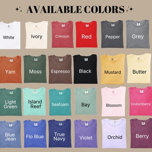 May include: A color chart displaying twenty-four folded t-shirts in various shades including white, ivory, crimson, red, pepper, grey, yam, moss, espresso, black, mustard, butter, light green, island reef, seafoam, bay, blossom, crunchberry, blue jean, flo blue, true navy, violet, orchid, and berry.