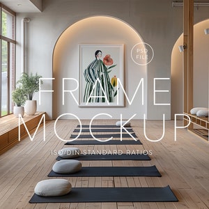 以下が含まれることがあります： 木製の床と大きな窓のある部屋に、白いフレームのモックアップがあります。フレームは白い背景の壁に掛けられています。フレームは空で、あなたのデザインのために準備されています。部屋はいくつかの植物とヨガマットで飾られています。フレームの前にある床には、「FRAME MOCKUP ISO/DIN STANDARD RATIOS」というテキストが書かれています。