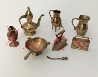 Puede incluir: Un conjunto de artículos de cocina de latón en miniatura, que incluyen una tetera, una jarra, una sartén, una plancha, una lámpara y una radio. Todos los artículos están hechos de latón y tienen un acabado brillante.