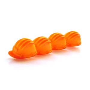 Puede incluir: Cuatro cascos de obra de color naranja brillante alineados en una fila.