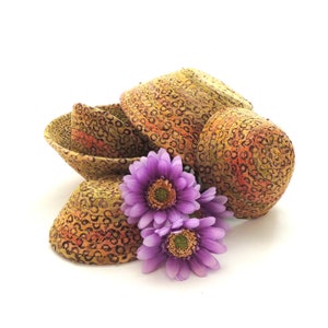 May include: A collection of decorative, patterned bowls and a single bowl, in shades of brown, orange, and yellow. The bowls are arranged with purple flowers on a white background. The bowls have a circular pattern.