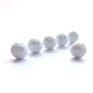 May include: Six small, light blue spheres arranged diagonally against a white background. The spheres have a textured, uneven surface, resembling miniature snowballs. The lighting creates soft shadows, enhancing the three-dimensional effect.