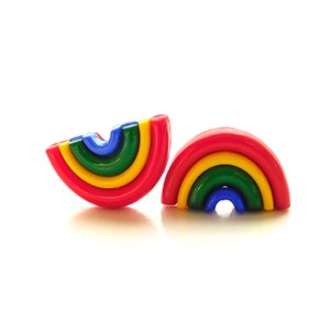 May include: A pair of rainbow-colored plastic earrings. Each earring is shaped like a half-circle with a layered rainbow design in red, yellow, green, and blue.