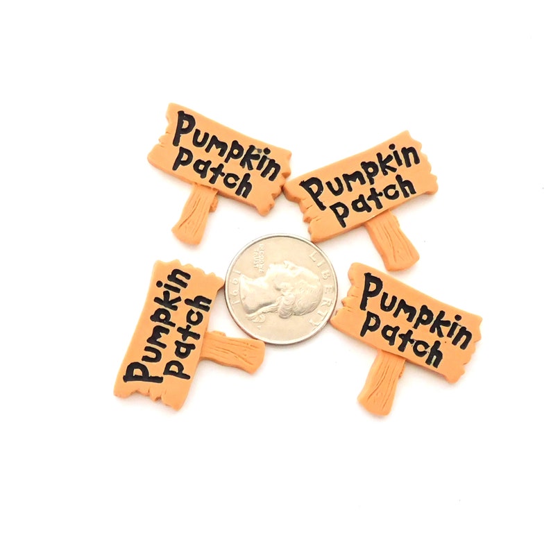 K&ouml;nnte beinhalten: Vier kleine Holzschilder mit der Aufschrift "Pumpkin Patch" in schwarzer Farbe. Die Schilder sind etwa so gro&szlig; wie eine US-amerikanische 25-Cent-M&uuml;nze.