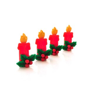 May include: Four red candle decorations with yellow flames, accented with green holly leaves and red berries. These festive decorations are perfect for holiday crafts and seasonal decor.