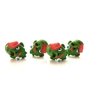 May include: Four green and red zombie head buttons with white eyes.