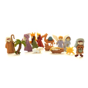 May include: A set of 12 wooden Christmas nativity figures, including a camel, a shepherd, a palm tree, a star, an angel, and three wise men. The figures are painted in various colors, including brown, green, blue, yellow, and red.