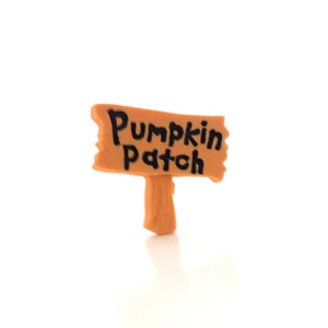 K&ouml;nnte beinhalten: Ein kleines Holzschild mit braunem Hintergrund und schwarzem Text, auf dem "Pumpkin Patch" steht.