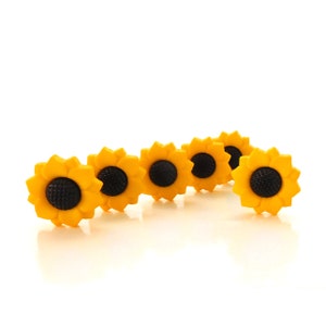 May include: Five yellow sunflower-shaped buttons with black centers.