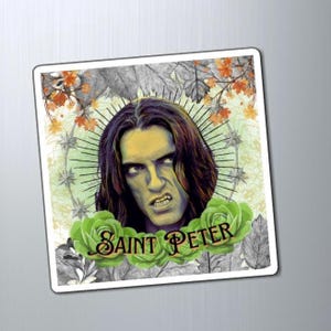 May include: A rectangular magnet featuring an illustration of a man with long dark hair and an intense expression. The image is framed by green roses and the text "Saint Peter". The background includes a halo and autumn leaves.