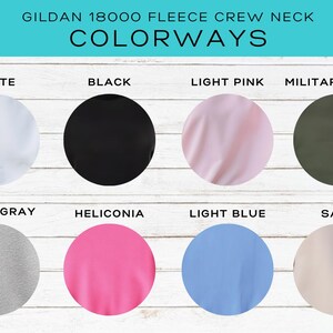 May include: Image showcasing the color options for a Gildan 18000 fleece crew neck sweatshirt. The colorways include white, black, light pink, military green, sport gray, heliconia, light blue, and sand. The brand name is Briggs Design Apparel.