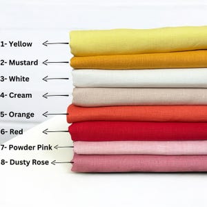 Op de afbeelding: Een stapel van acht stofstalen in verschillende kleuren, waaronder geel, mosterd, wit, cr&egrave;me, oranje, rood, poederroze en stoffig roze. De stalen zijn genummerd en met de kleurnaam gelabeld.