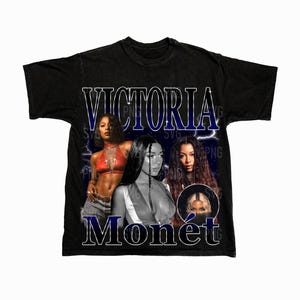 May include: Black t-shirt with a graphic print of three women. The text "VICTORIA MONET" is printed in blue on the shirt.