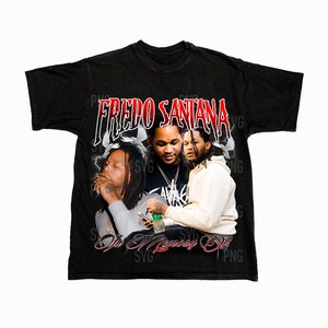 May include: Black t-shirt with a faded look featuring a photo of two men with the text "Fredo Santana In Memory Of" in red.