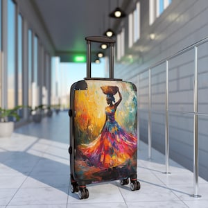 May include: A rolling suitcase with a vibrant painting of a woman carrying a basket on her head. The artwork features a colorful dress and a warm, abstract background. The suitcase has a black handle and wheels.