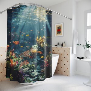 May include: A colorful shower curtain featuring an underwater scene with coral reefs, tropical fish, and sunlight shining through the water.