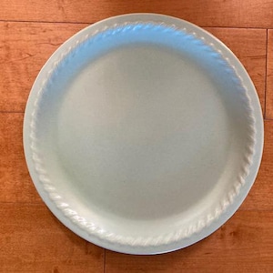 May include: A light green ceramic pie plate with a rope-like design around the edge.