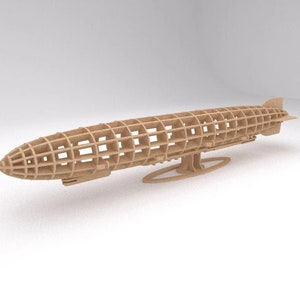 May include: A wooden model of a dirigible or airship, with a detailed framework and a stand. The model is made of light brown wood and is in a neutral background.